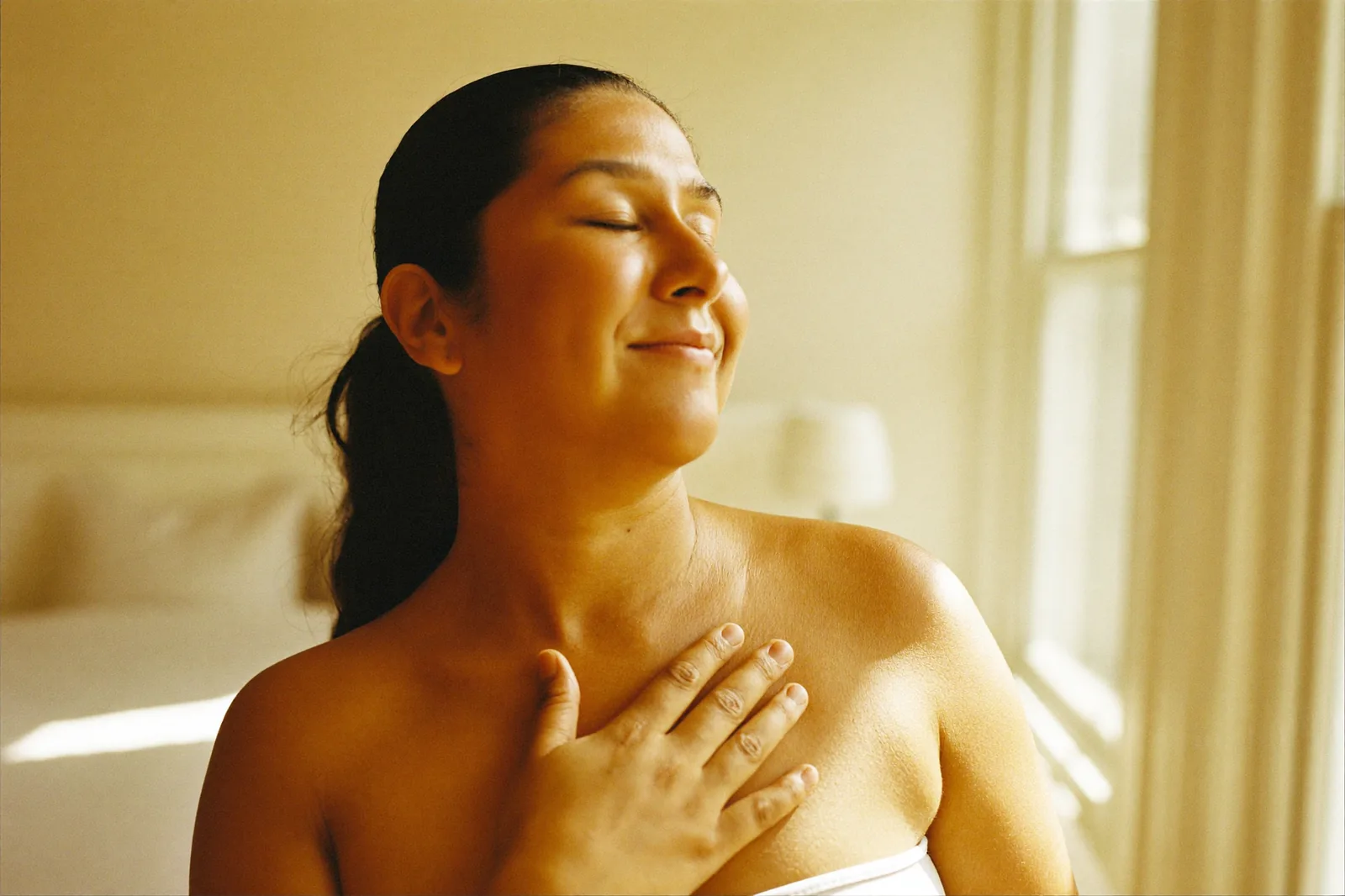 Mujer en calma por la mañana, respirando junto a la ventana